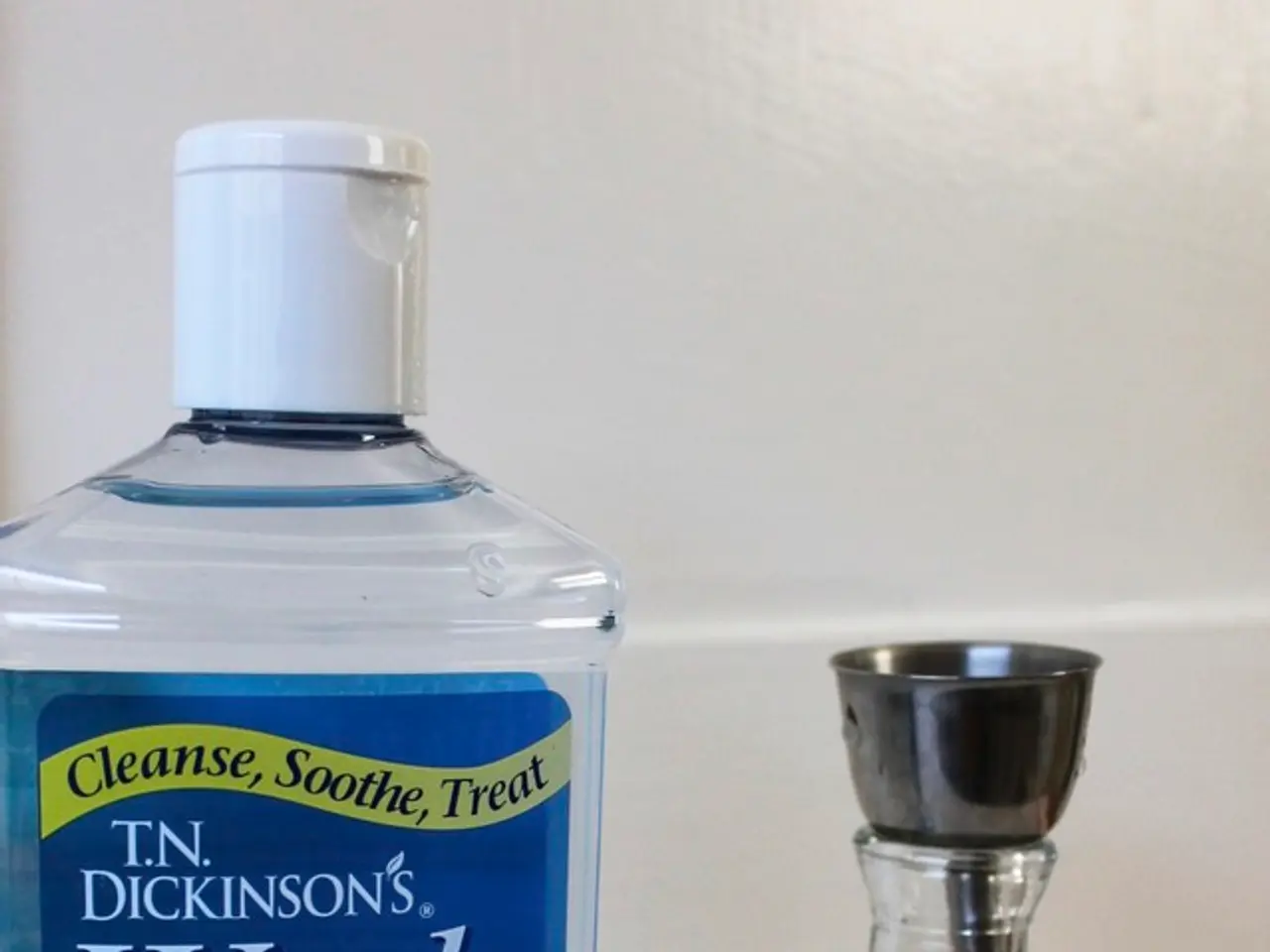 On the table there is a bottle with label on it and a glass bottle with steel cap.