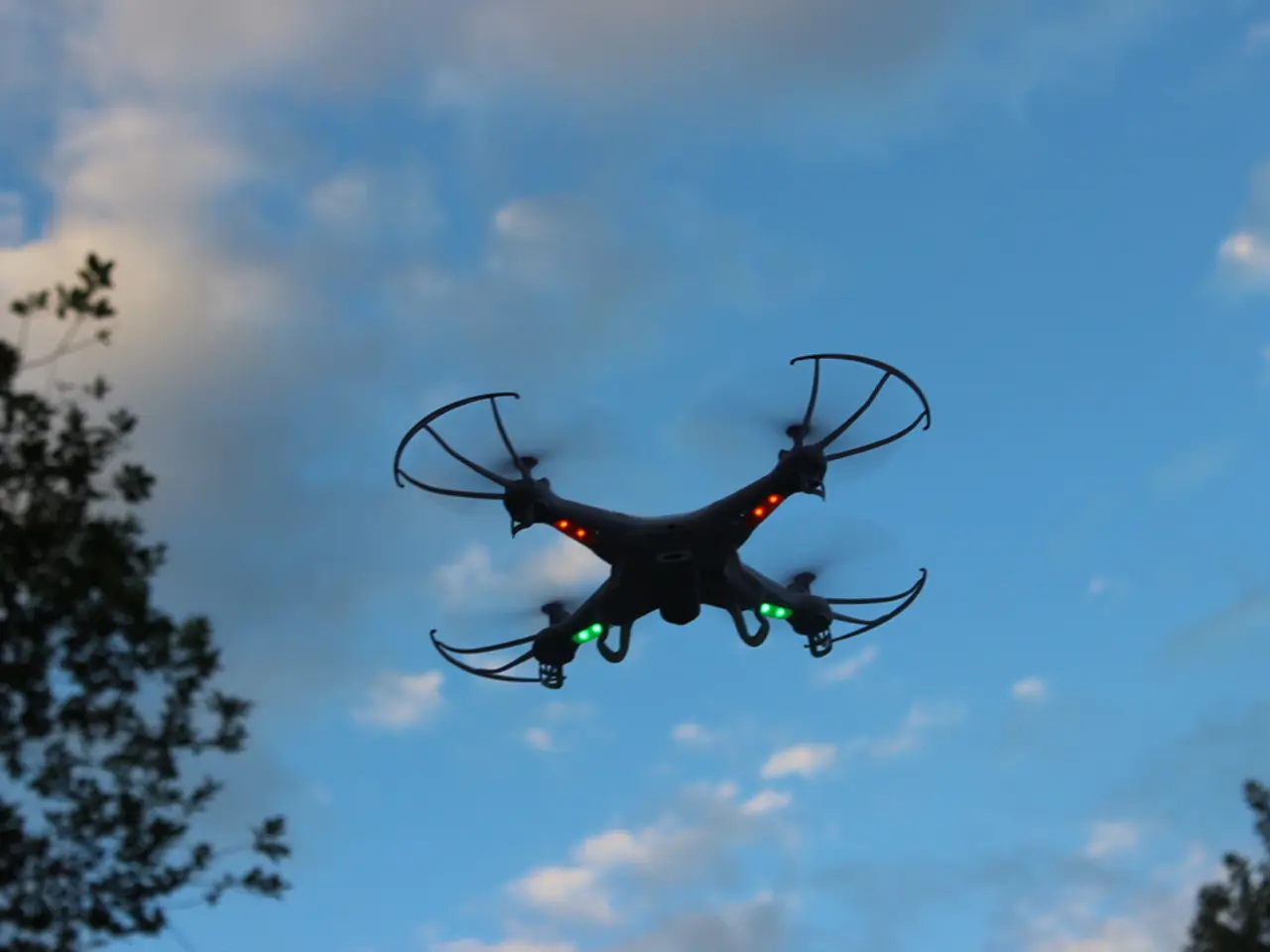 In the middle I can see a drone camera. The background is covered with trees and the sky. This...
