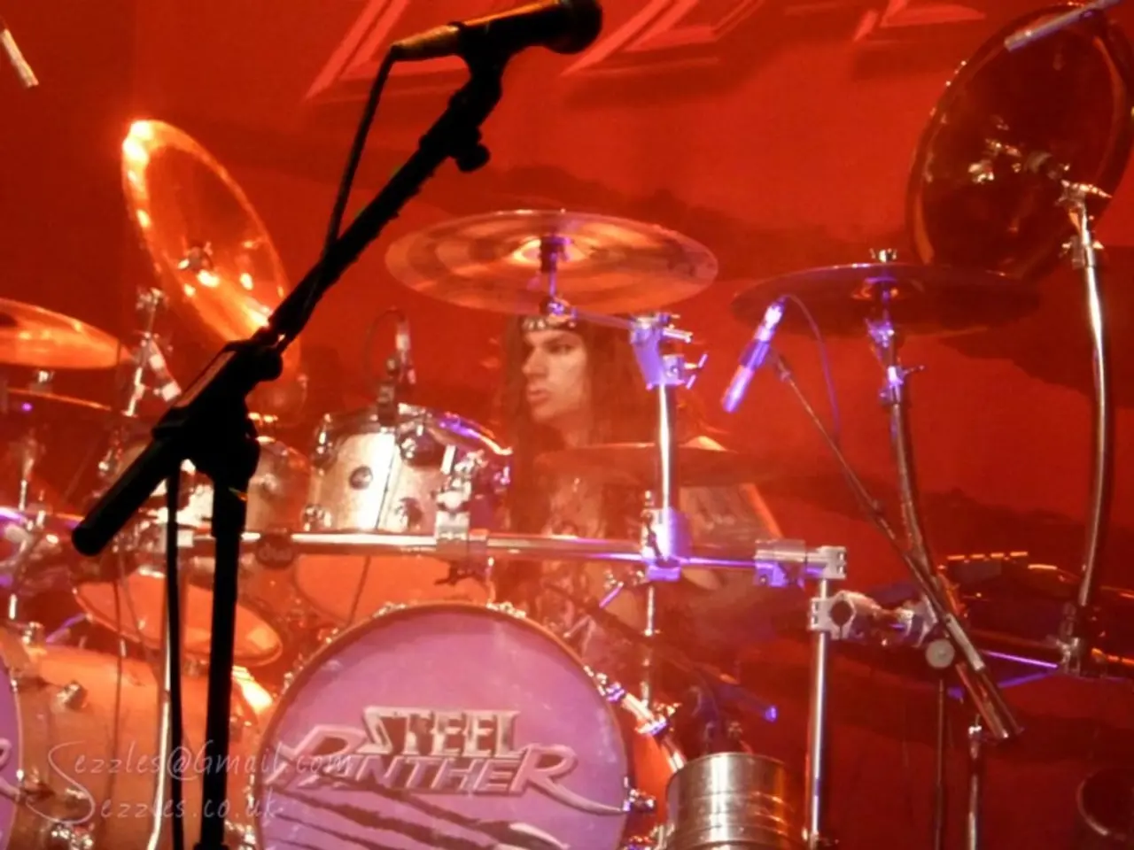 In the image there is a music band,a person is playing the band and around that area there is a lot...