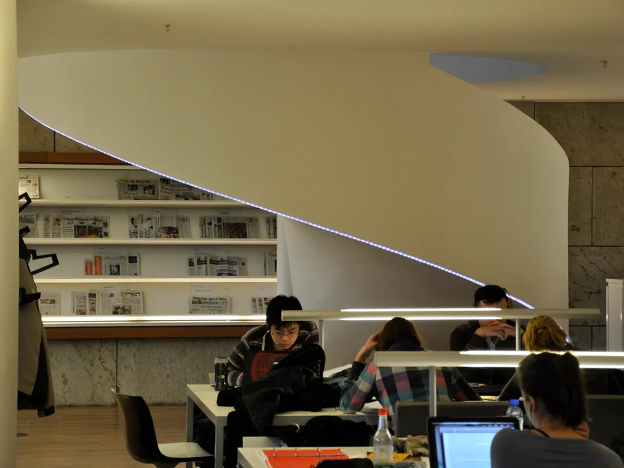 In this picture there are some people sitting in the chairs in front of a tables on which some...