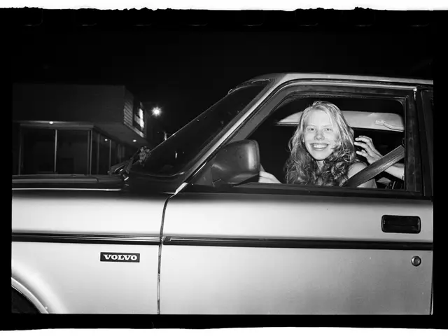 In this picture a woman is sitting inside the car having a smile on her face. Outside that there is...