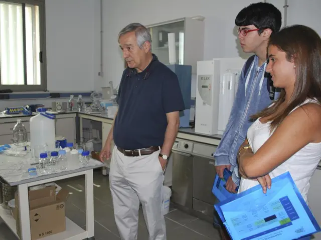 In this image we can see some people standing on the floor. In that we can see a man and a woman...