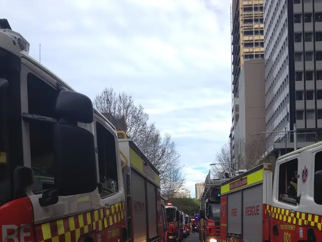 In this picture there are trucks in a line which are on either side of the road. The trucks are in...