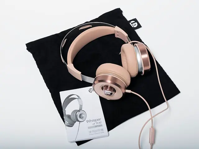 There is headphone, manual on a black color cloth in the foreground.